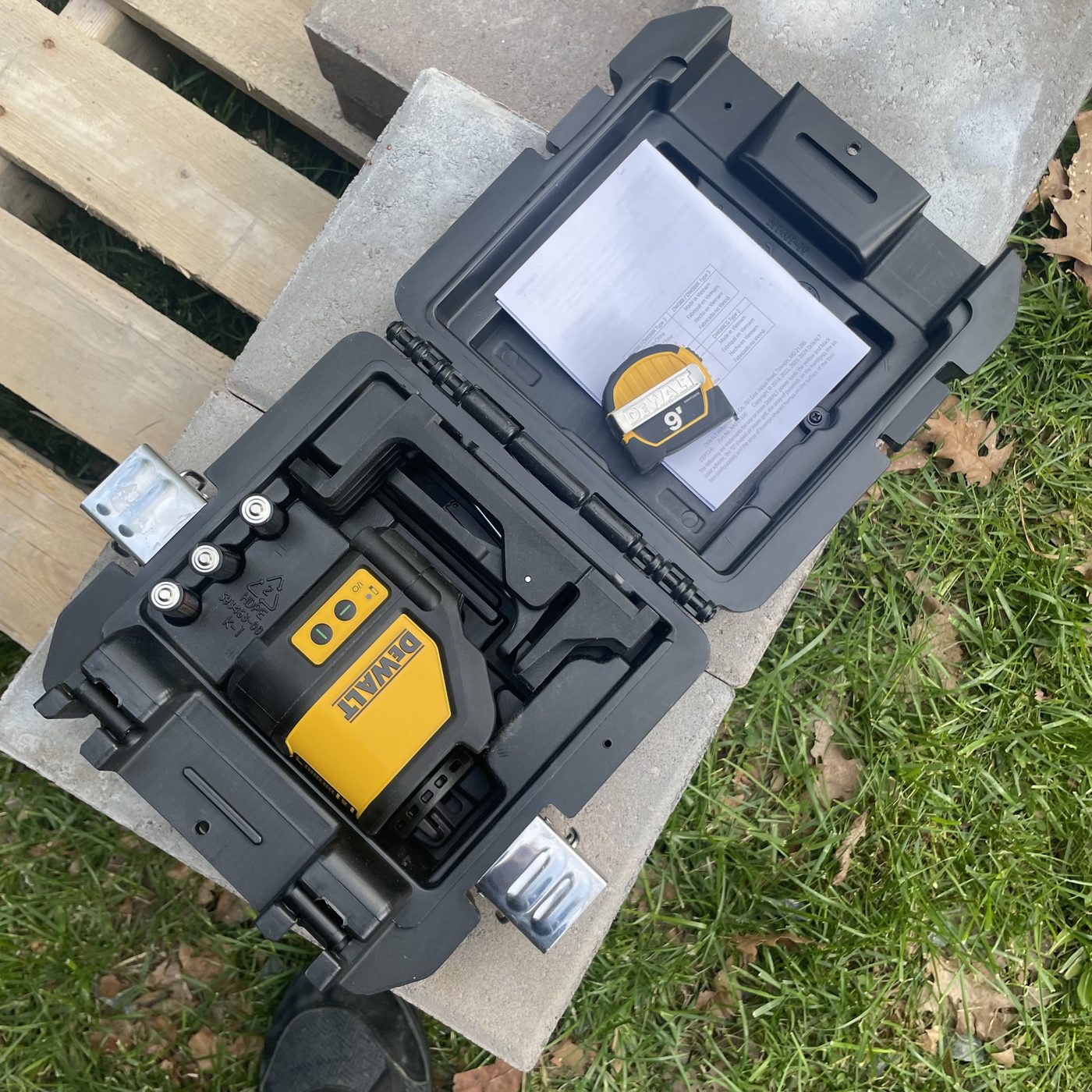 Cross-line laser level in its case on a paver