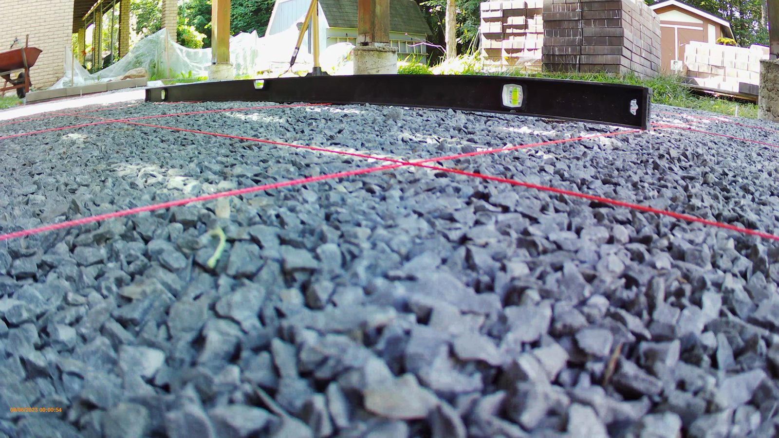 Compacted gravel base with string lines and a level