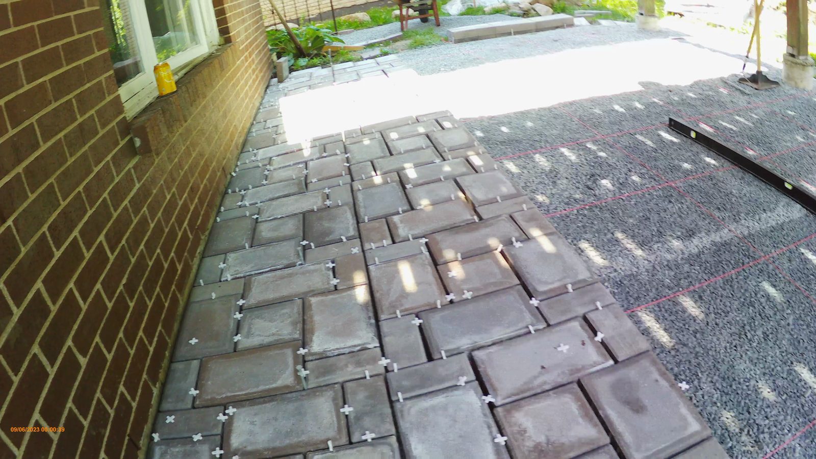 First rows of pavers laid along the house wall