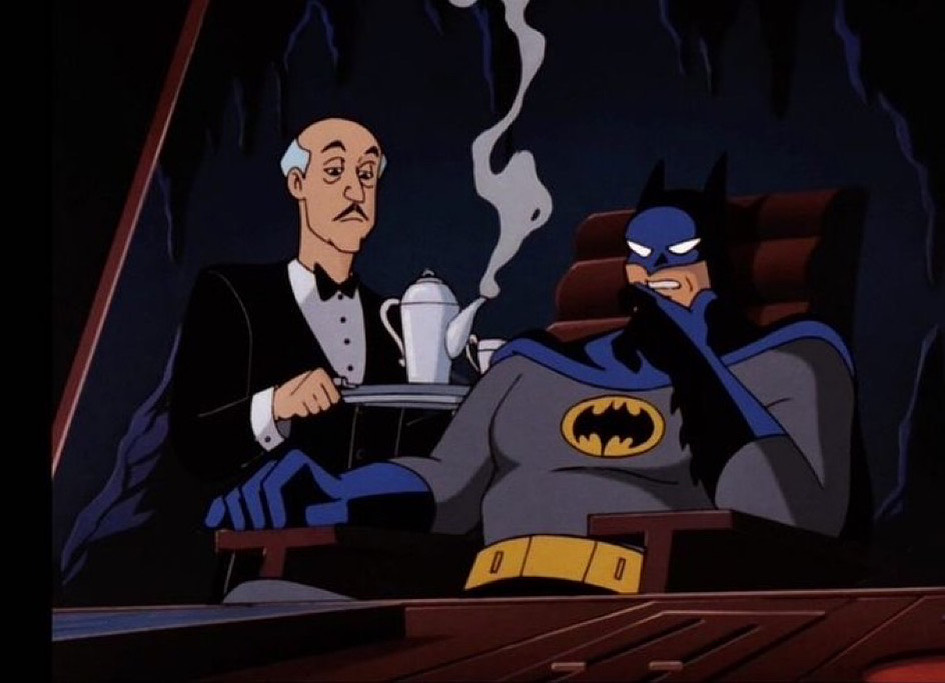 Batman brooding in the cave while Alfred brings coffee